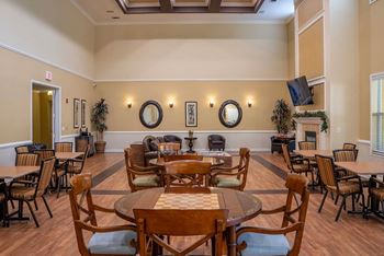A room with wooden chairs and tables arranged for a meeting.